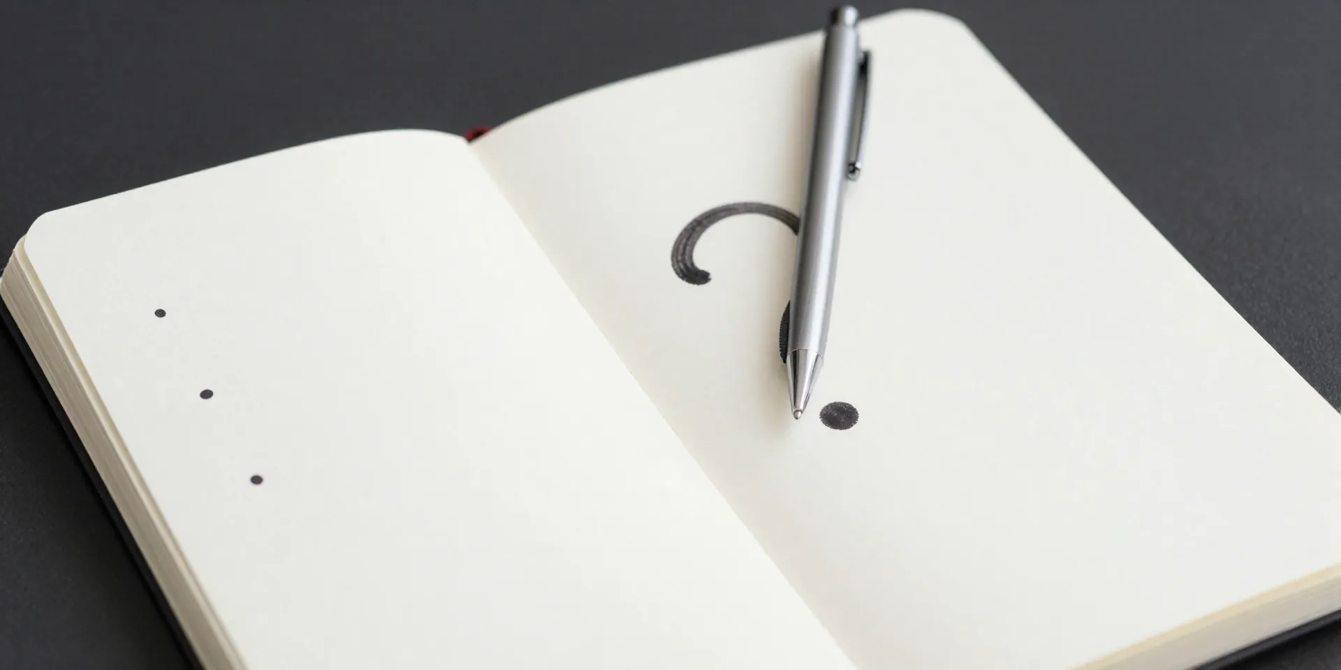A minimalist notebook open to a clean page with three bullet points and a question mark. A pen resting neatly beside it