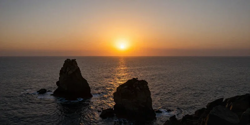FPV drone perspective flying directly toward a massive blazing sun setting over an ocean, foreground features dark