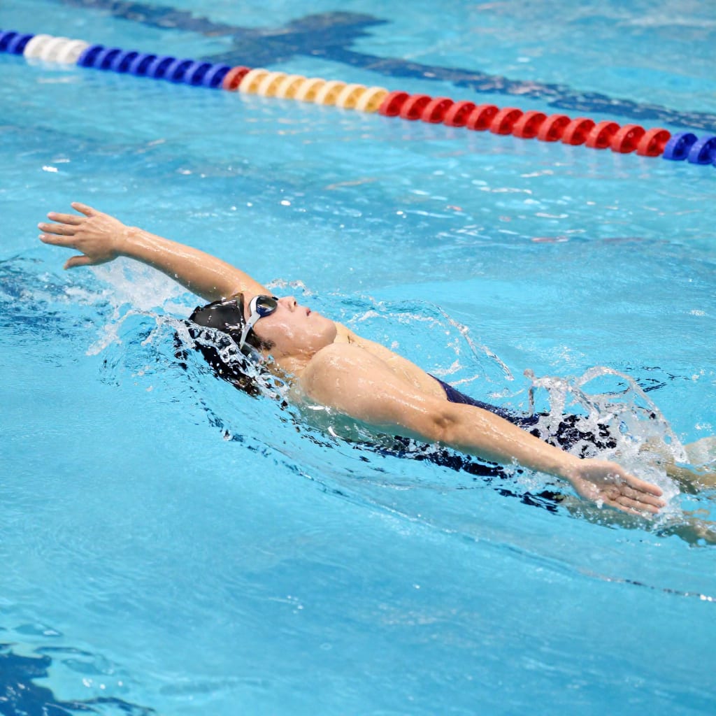 Swimmer performing catch-up drill with pull buoy